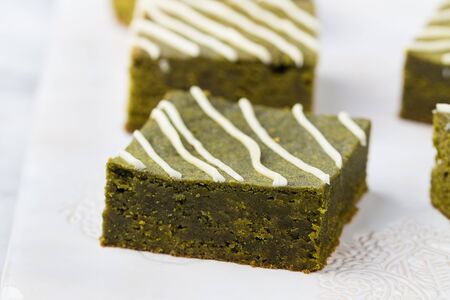 Matcha green tea brownie cake with white chocolate on a white plate Grey stone backgroundの写真素材