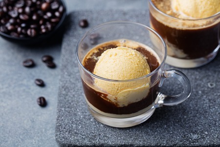 Affogato coffee with ice cream on a glass cup Grey slate background.