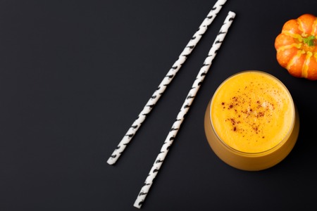 Pumpkin smoothie with pumpkin pie spices on a black slate stone background Top view. Copy space.の写真素材
