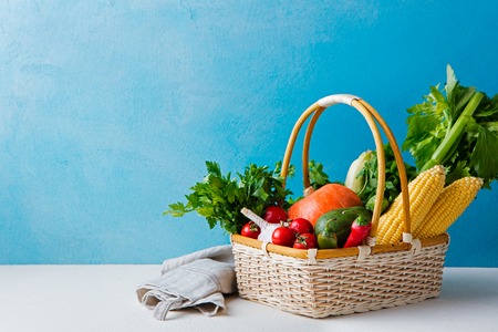 Basket of fresh vegetables on a blue background. Copy spaceの写真素材