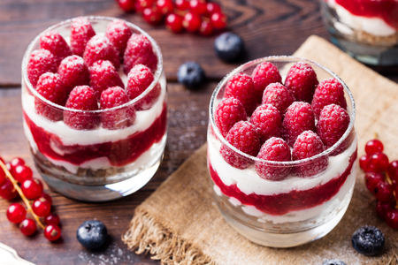 Raspberry dessert, cheesecake, trifle, mouse in a glass on a wooden backgroundの写真素材