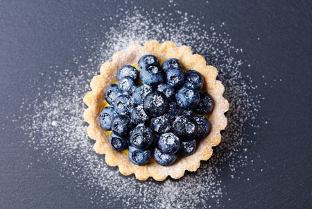 Blueberry tart, pie, tart with vanilla custard. Slate stone background. Top view. Copy space.の写真素材