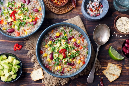 Vegetable quinoa soup, stew with avocado, corn, beans. South American traditional dish. Top view