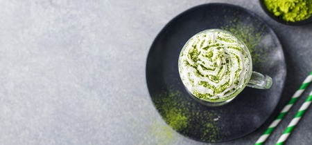 Matcha green tea latte with whipped cream. Top view. Copy space