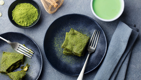 Matcha green tea cake, bars, brownie with white chocolate on a plate. Grey background. Top viewの写真素材
