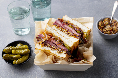 Sandwich with roast beef in wooden box. Grey stone background. Close upの写真素材