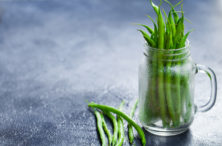 Green beans in glass jar on grey stone background. Copy space.の写真素材