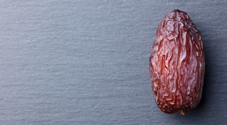 Fresh Medjool Dates. Slate stone background. Top view. Copy space.