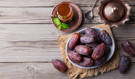 Fresh Medjool Dates in a bowl with teaの写真素材