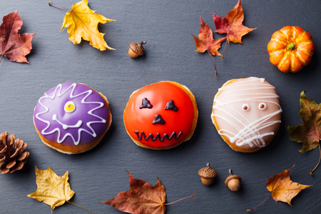 Donuts with Halloween decoration, icing on black slateの写真素材