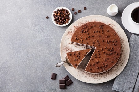 Tiramisu cake with chocolate decoration on a plate.