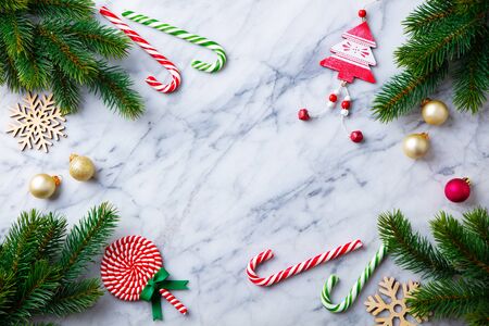 Christmas, New Year decorations, candy cane and fir branches on marble background. Top view. Copy space.の写真素材