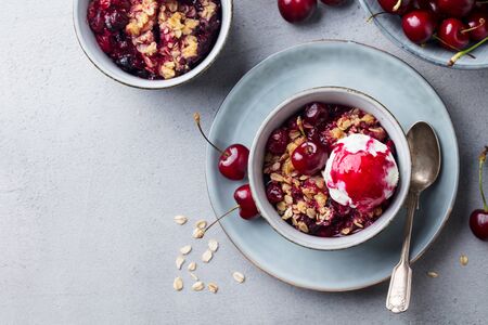 Cherry crumble with ice cream in bowl. Grey background. Copy space. Top view.の写真素材
