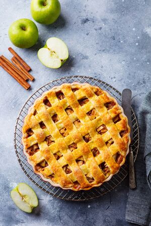 Apple pie with caramel on a cooling rack. Grey background. Copy space. Top view.の写真素材