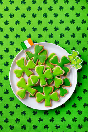 Shamrock cookies with Irish flag, St. Patricks Day dessert. Green textile background. Top view.の写真素材