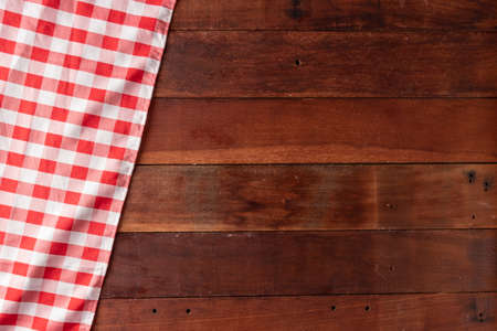 rustic wooden table background with red checkered tableclothの写真素材