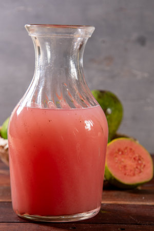 Jug of guava juice on rustic wooden tableの写真素材