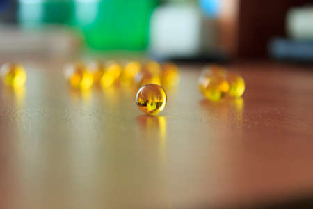 Vitamin in the capsule lies on the table compared to other capsulesの写真素材