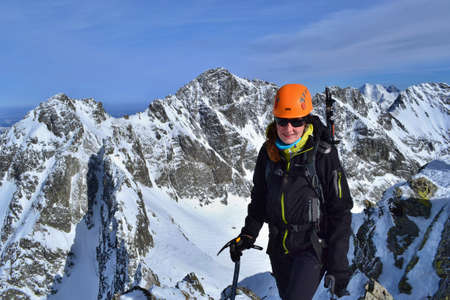 TATRA MOUNTAINS, SLOVAKIA - FEBRUARY 23, 2019: Young girl is standing at the summit of Koprovsky...