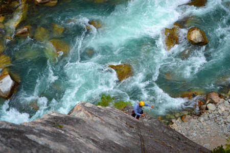 Star Chek Climbing the majestic multi-pitch route south of Whistler. Young man rappels climbing the...