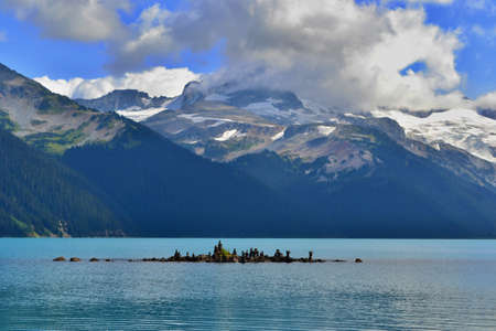 Beautiful blue Garibaldi Lake surrounded by high mountains with glaciers. Mysterious white and gray...