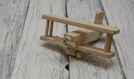 Wooden airplane without painting on the background of light boards