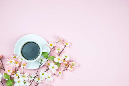 A cup of black aromatic coffee with pink flowers. Light pink backgroundの写真素材