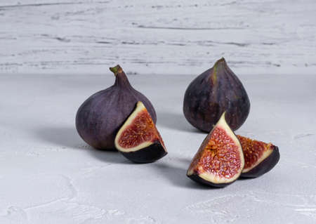Whole and sliced ripe figs on a bright tableの写真素材