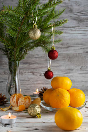 Tangerines in a transparent plate on a light wooden tableの写真素材
