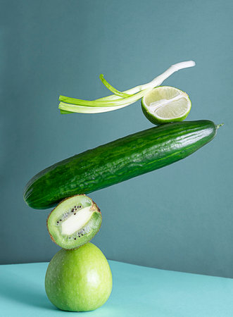 Balance of green products. Green apple, lime, cucumber, kiwi and green onion stand on top of each otherの写真素材