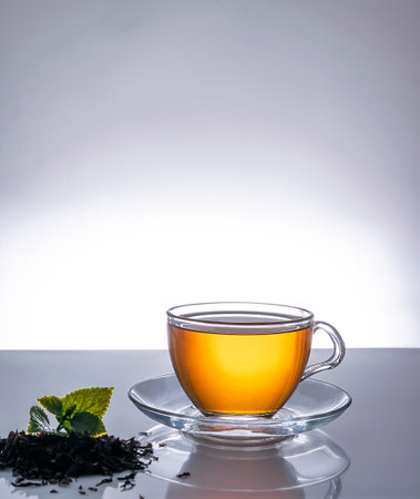 Fragrant hot tea in a transparent cup on a saucerの写真素材