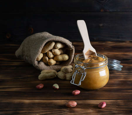 Their peanut paste in a transparent jar on a dark brown wooden table