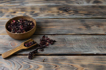 Brewing from rosella flowers in a wooden bowl on a light brown wooden tableの写真素材