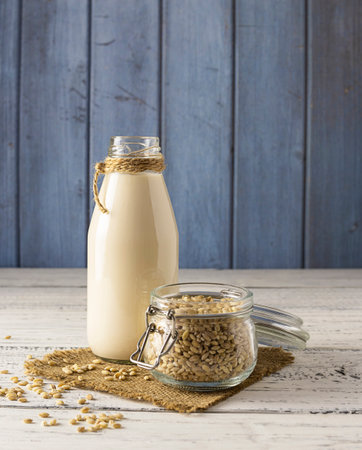 Transparent bottle with barley milk on a canvas napkinの写真素材