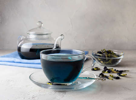 Blue tea from clitoria flowers in a transparent cup on a light tableの写真素材
