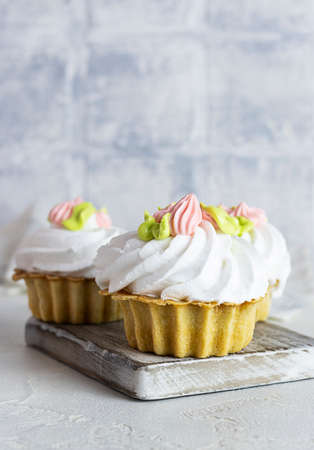 Shortbread baskets with air cream on a wooden plank. light background. close-up