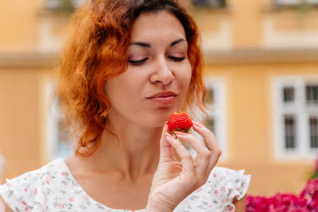 Portrait of the beautiful young woman with fresh red strawberries. Girl enjoy eating appetizing and juicy strawberry. Healthy food. Selective focusの写真素材