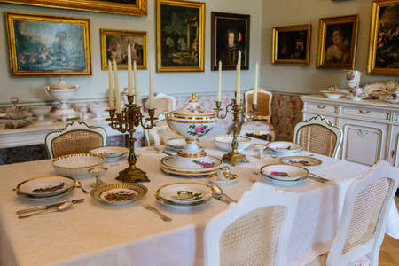 Castle interior. Living room with table and chairs. Porcelain dishes and candelabra stand on the table. Chateau in classicist style. Castle Duchcov, Czech Republic, September 19, 2020のeditorial素材