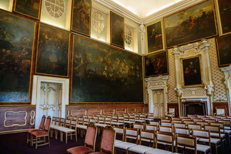 Castle interior. Great hall with paintings. White and gold stucco on the walls. Castle Duchcov,...