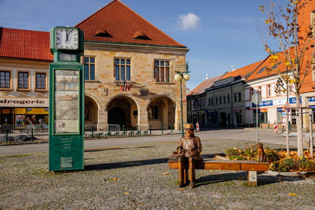 Wooden sculpture of Czech writer Bohumil Hrabal, bench with a cat, Premyslid Square and Hlav's house in sunny autumn day, Nymburk, Central Bohemia, Czech Republic, November 17, 2020のeditorial素材