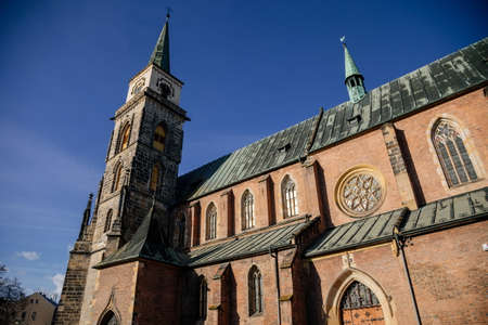 Medieval catholic church of Saint Jilji with gothic high clock tower in sunny autumn day, Nymburk, Central Bohemia, Czech Republic, November 17, 2020のeditorial素材