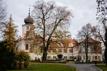 Loucen Rococo castle surrounded by a vast English park, Romantic baroque chateau with Church of the Assumption of the Virgin Mary in autumn day, Central Bohemia, Czech republic, November 22, 2020のeditorial素材