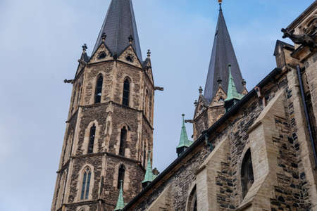Medieval stone St. Bartholomew? S Church in autumn day, arched windows, chimeras and gargoyles,...