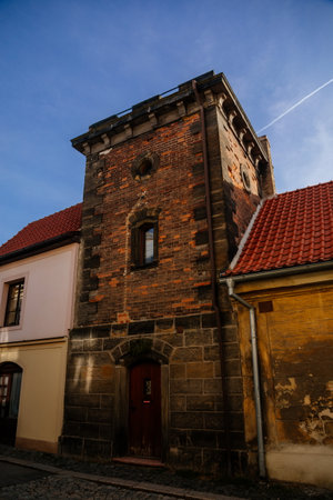 Narrow picturesque street with colorful buildings in old historic center in medieval city Slany, yellow renaissance house with stone tower, Central Bohemia, Czech Republic, December 27, 2020のeditorial素材