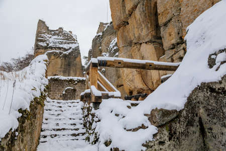 Restored oak wood draw-well winch, ancient ruins of old gothic medieval castle Helfenburk u Usteka tower under snow in winter day, North Bohemia, Czech Republic, January 16, 2021のeditorial素材