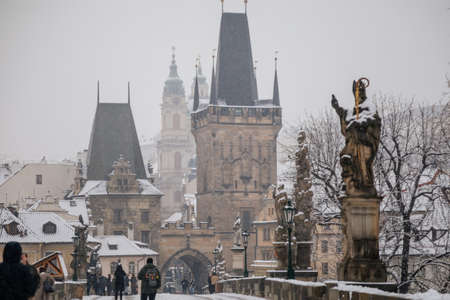 Charles Bridge landmark looking towards Lesser Town with bridge tower, Baroque Church of Saint Nicholas and Prague Castle in background, snow in winter day, Prague, Czech Republic, January 26, 2021のeditorial素材