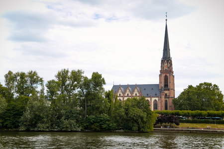 Church of the Three Kings or Dreikonigskirche, Lutheran Protestant church and parish, Gothic revival style, bell tower, trees green leaves, sunny summer day Frankfurt am Main, Germany, July 07, 2019のeditorial素材