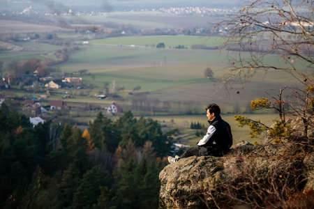 Aerial view from Drabske svetnicky, Autumn sandstone landscape of Bohemian Paradise in sunny day, Sandstone cliffs, man sits on stone, looks into the distance, Czech Republic, December 05, 2020のeditorial素材