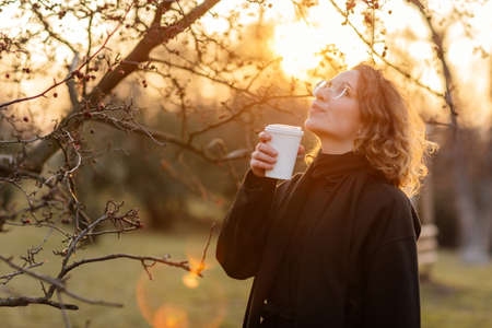 Beautiful young Caucasian woman enjoy sunny spring day, park, cherry garden, romantic portrait,...