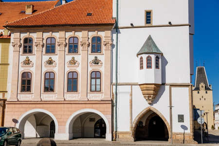 Main town Peace square, gothic white city hall tower, Mikulov Gate, Medieval narrow street, renaissance and baroque historical buildings, arcade, sunny day, Kadan, Czech Republic, April 04, 2021のeditorial素材